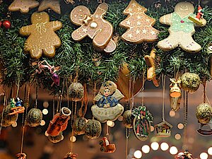 An einer Tanne hängen Lebkuchenfiguren und weihnachtliche Anhänger.